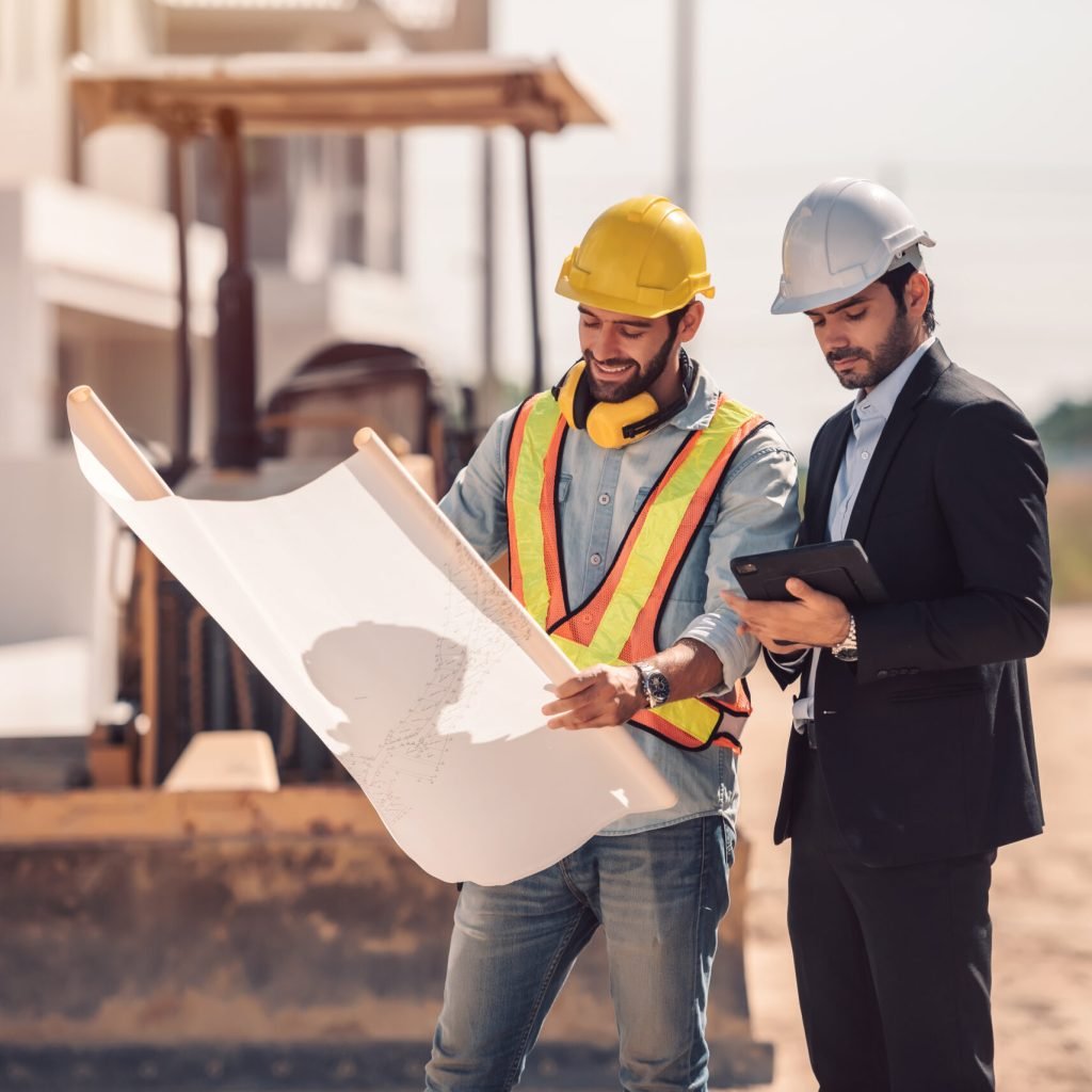 Civil engineer and construction worker manager holding digital tablet and blueprints , talking and planing about construction site.  Cooperation teamwork concept.