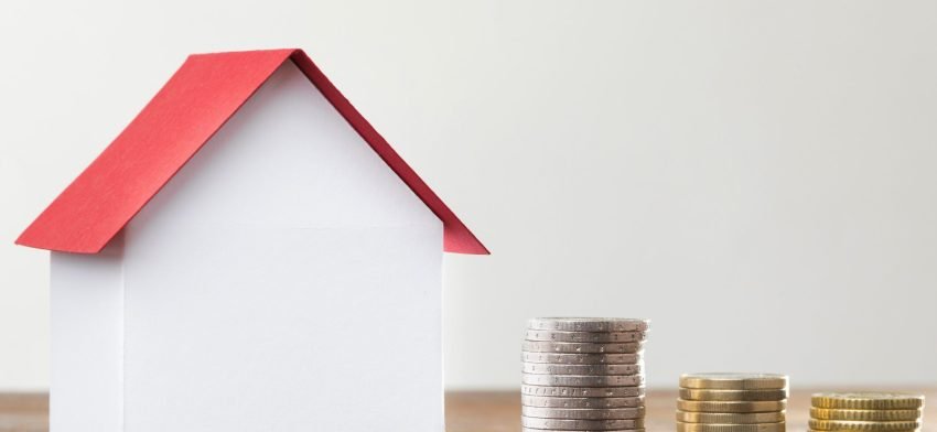 stack-coins-with-miniature-bank-beside